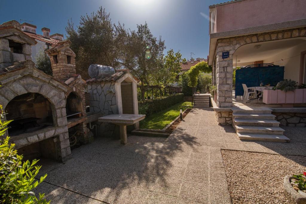a stone patio with a bench and a stone oven at Apartments Braut Krk in Krk