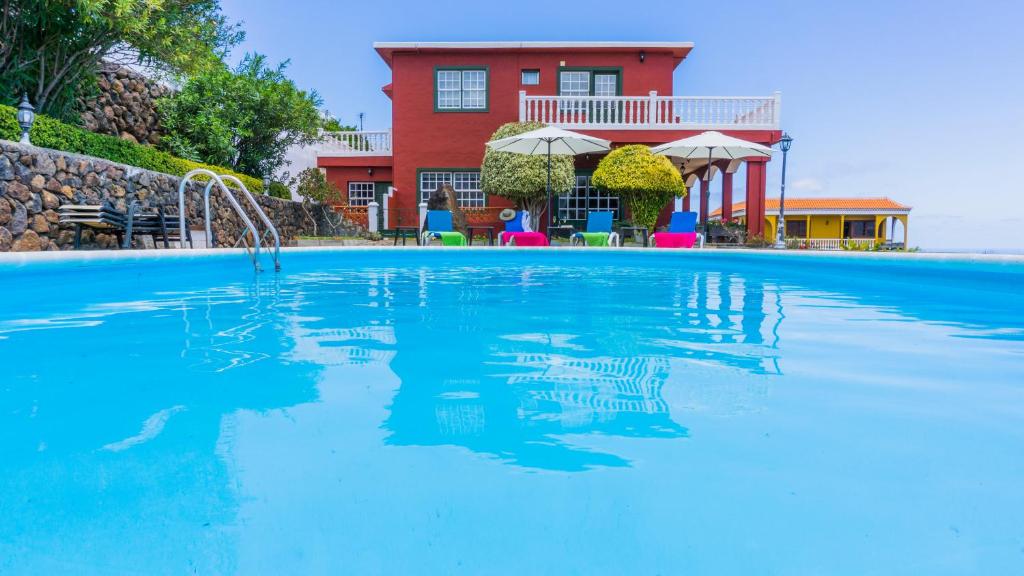 a swimming pool with a house in the background at La Rivera Apartments in Tenagua