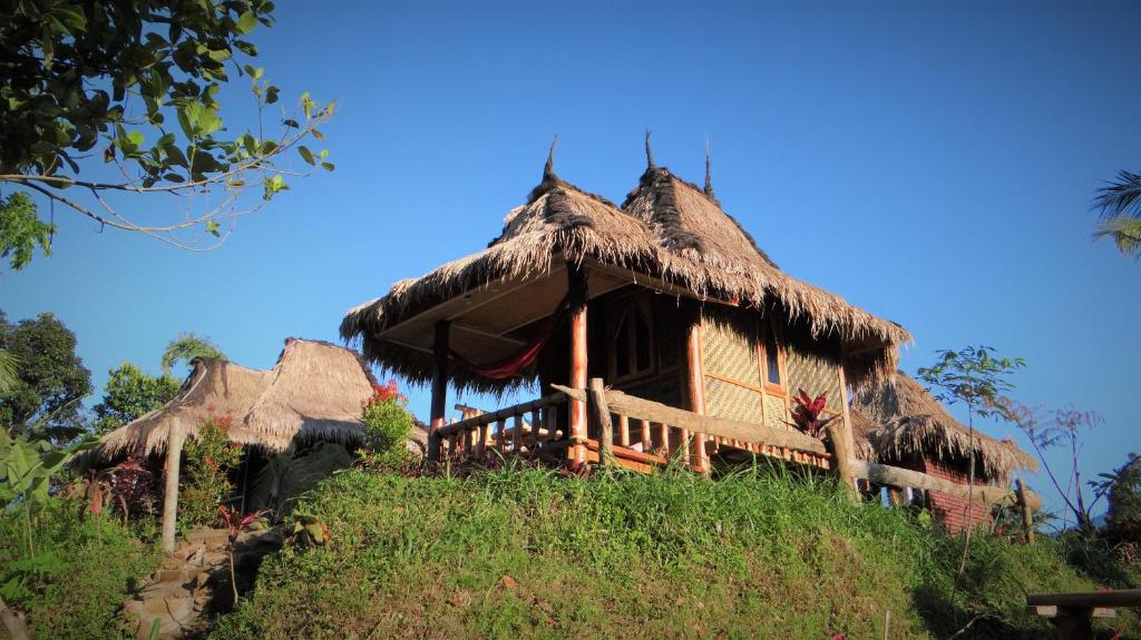 una casa con techo de paja en una colina en Satu Lingkung en Tetebatu