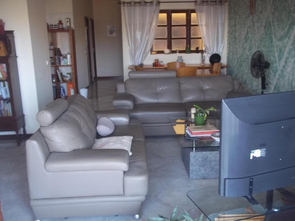 a living room with a couch and a tv at Ap Palmarejo in Praia