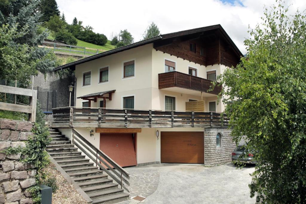 une grande maison avec un garage et un escalier dans l'établissement Apartment Kristyn, à Ortisei