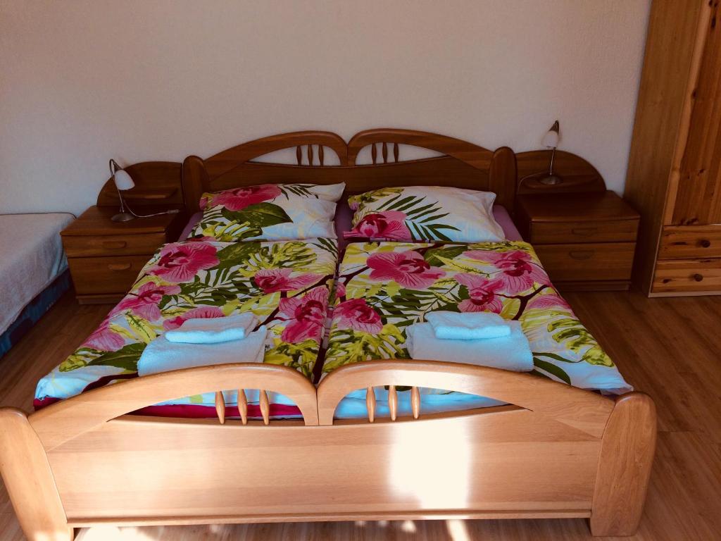 a bed with a wooden frame with flowers on it at Apartment Elli in Františkovy Lázně