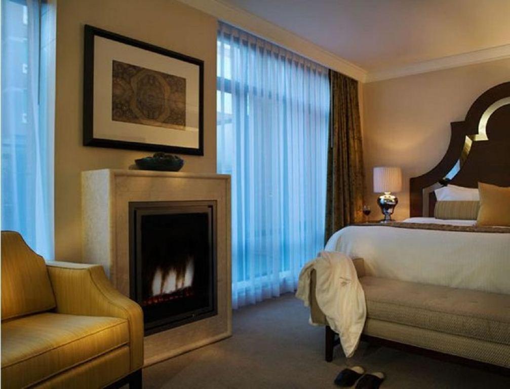 a hotel room with a bed and a fireplace at L'Hermitage Hotel in Vancouver