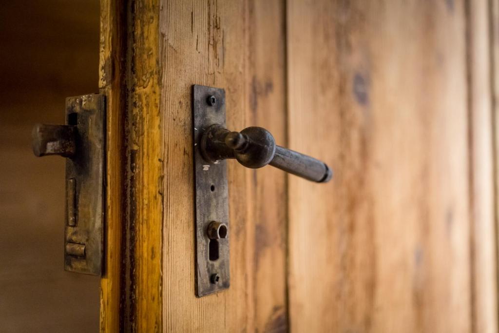 eine offene Holztür mit einem Türgriff aus Metall in der Unterkunft Rifugio Uschione in Chiavenna