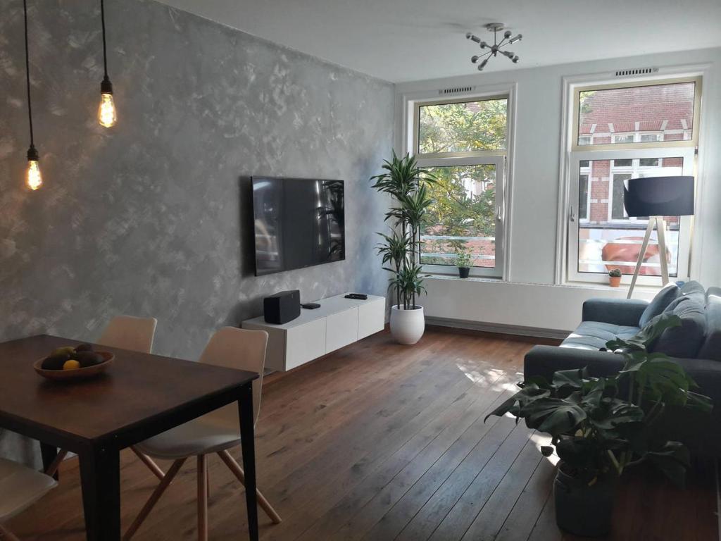 sala de estar con mesa y TV en la pared en Da Costastraat, en Ámsterdam