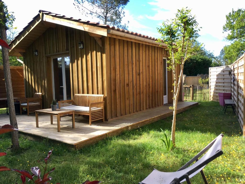 une cabine avec une terrasse en bois dans la cour dans l'établissement Escale sous les pins, à Salles