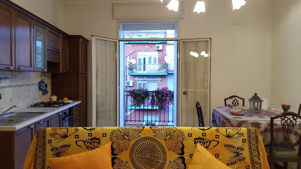 una cucina con divano, tavolo e finestra di Una casetta al centro di Napoli a Napoli