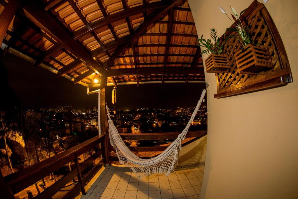 un balcón con hamaca y vistas a la ciudad en Pousada Casarão, en Jaraguá do Sul