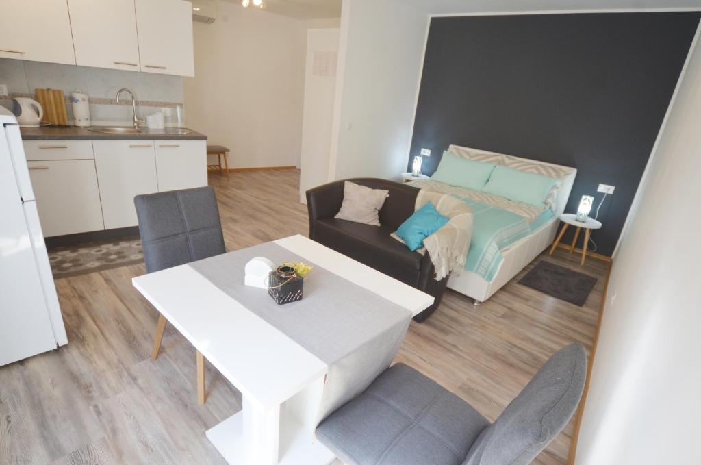 een keuken en een woonkamer met een tafel en een bed bij Studio Ana Carera in Rovinj
