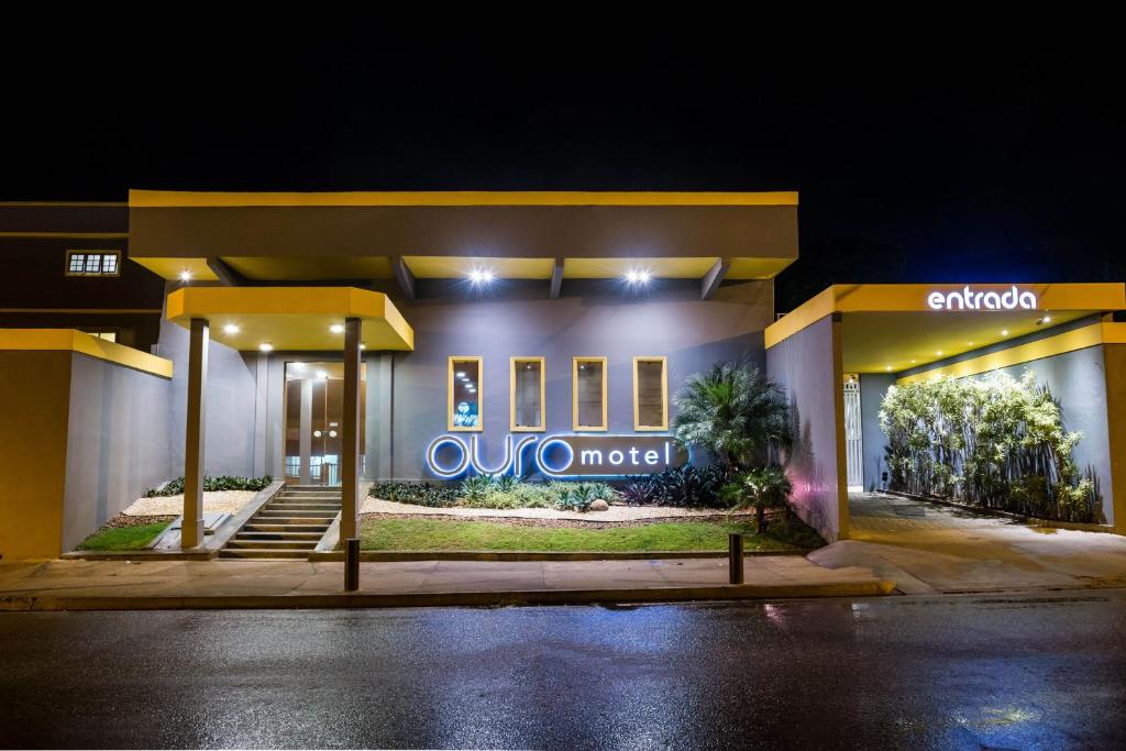 a gas station at night with a sign on it at Ouro Motel in Sepetiba