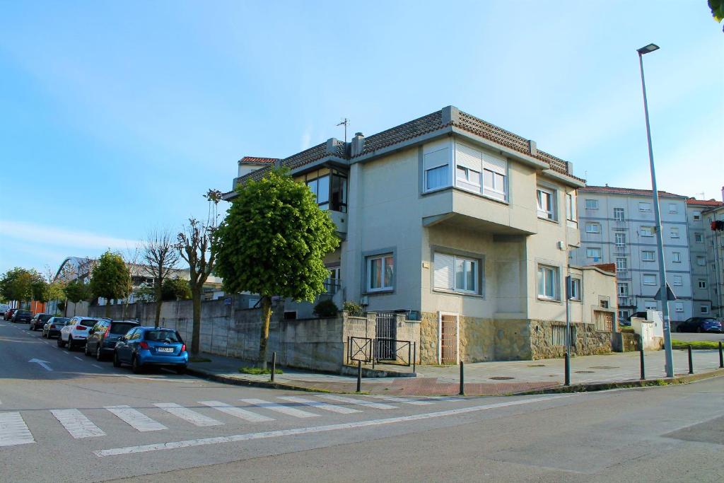 un edificio al lado de una calle con coches aparcados en Apartamentos Las Calas, en Santander