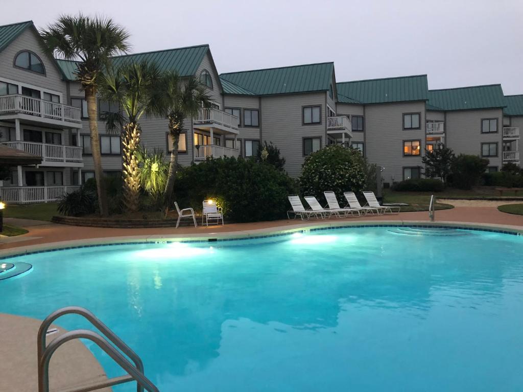 uma grande piscina em frente a alguns apartamentos em Gulf Shores Plantation em Gulf Shores