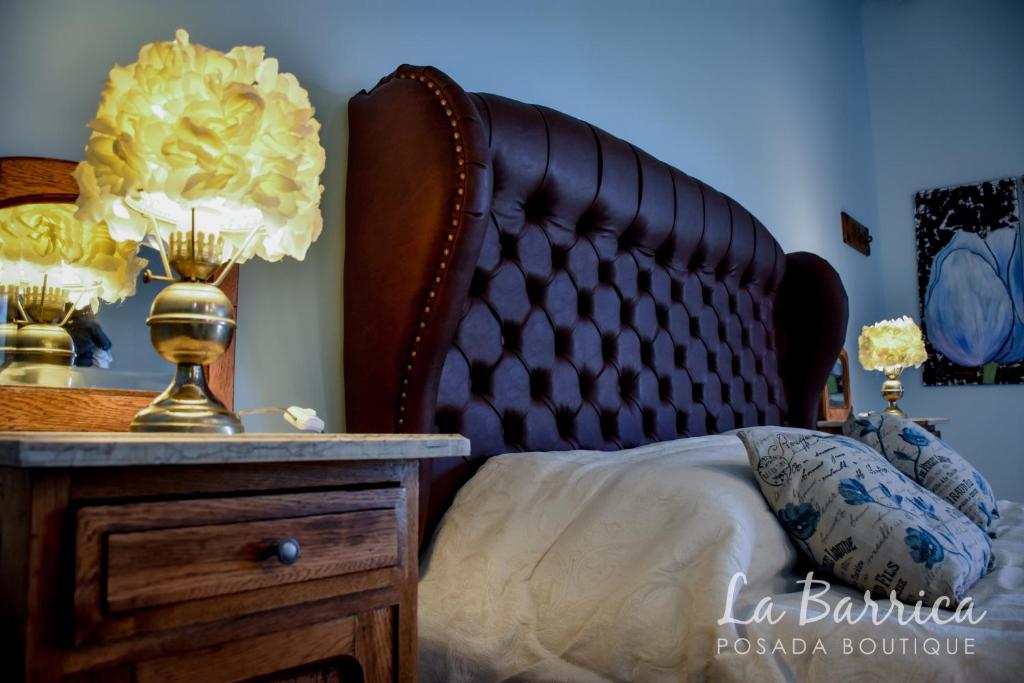 聖拉斐爾的住宿－Posada Boutique La Barrica，一间卧室配有一张床和一张带台灯的桌子