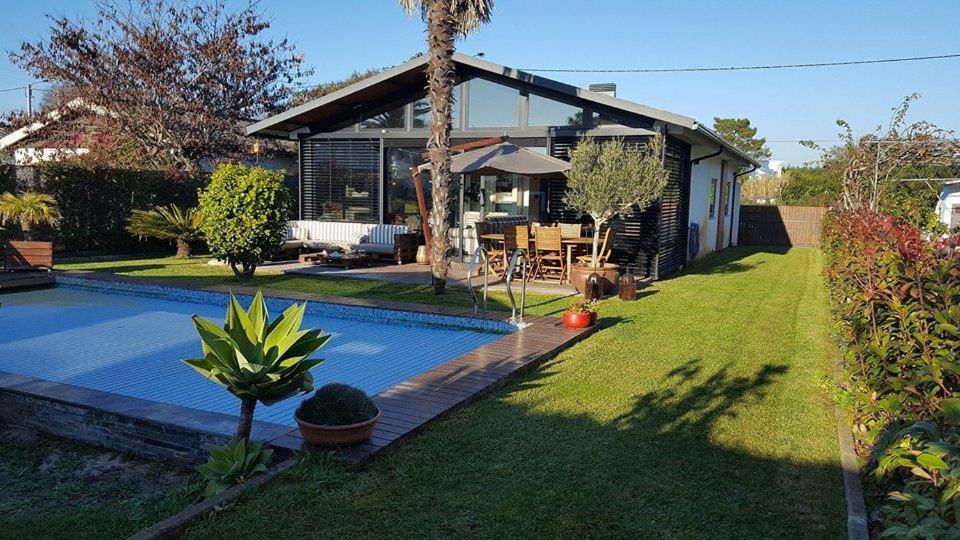 a house with a swimming pool in the yard at Casa dos Amigos - A luxury home in the nature in Torreira