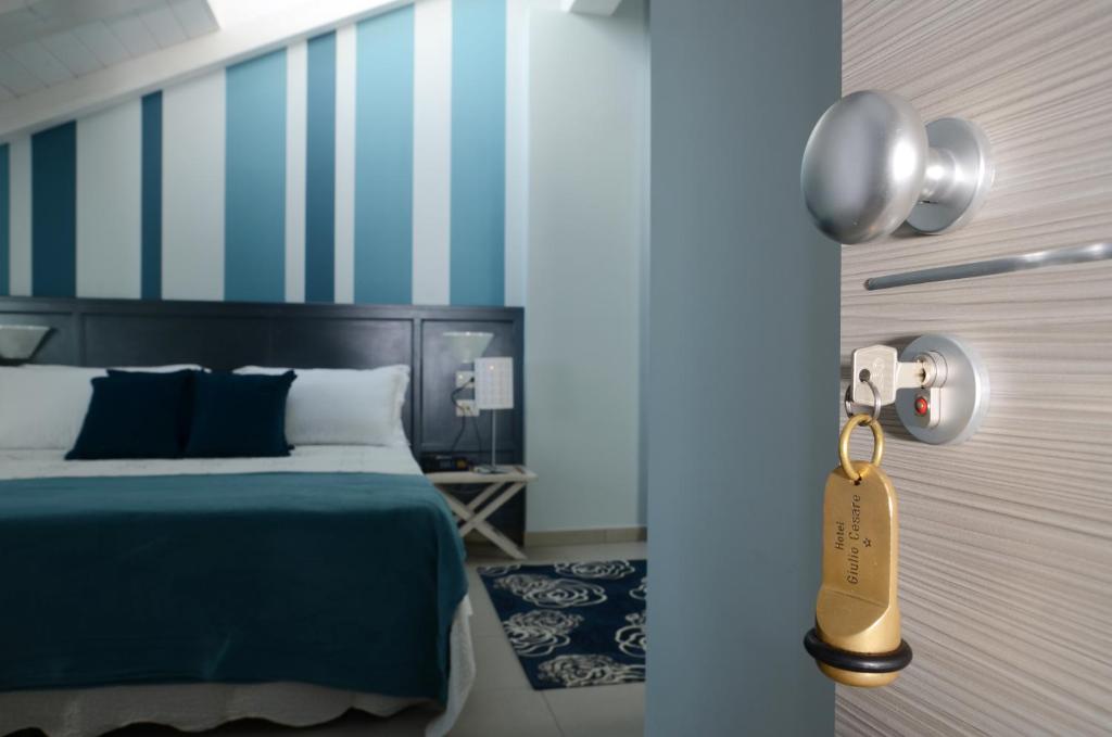 トリノにあるHotel Giulio Cesareのベッドルーム1室(青と白のストライプのベッド1台付)