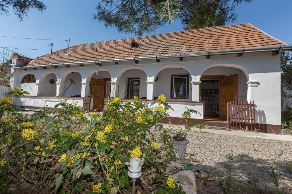 ein kleines weißes Haus mit braunem Dach in der Unterkunft Gádoros Vendégház in Egerszalók