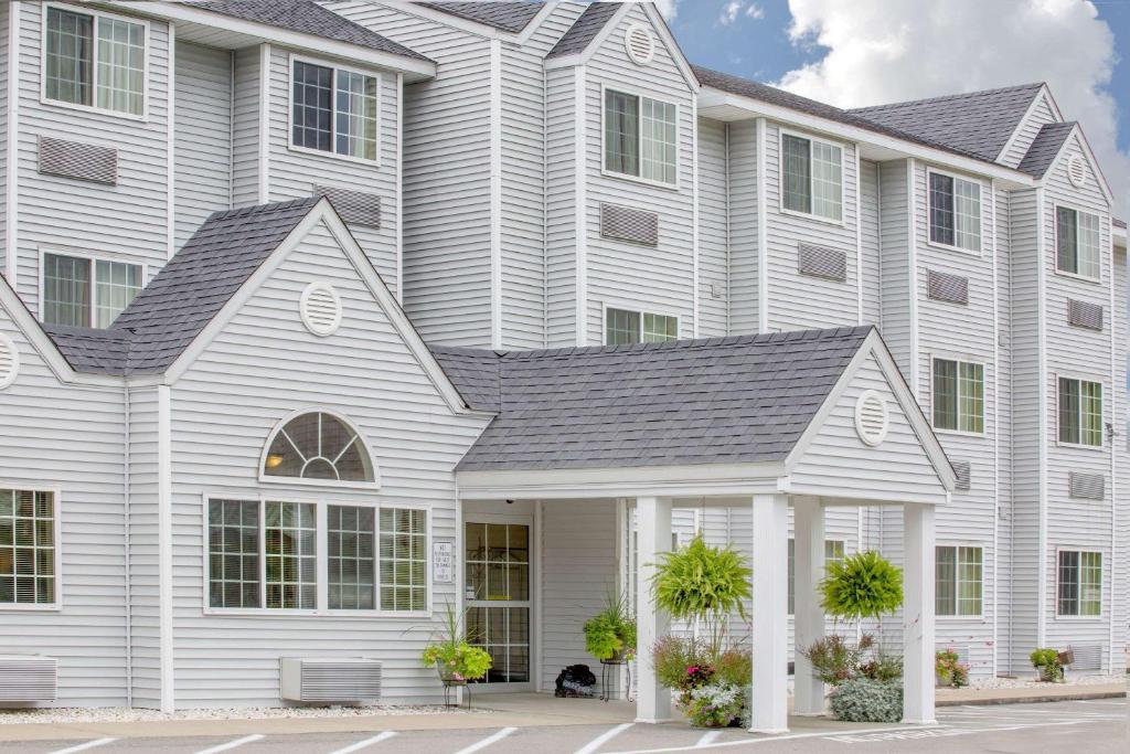 a large white house with white columns at Microtel Inn and Suites Gassaway in Bison