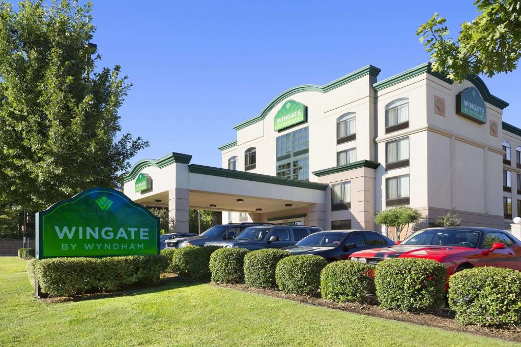 a hotel with cars parked in front of a building at Wingate by Wyndham Little Rock in Little Rock