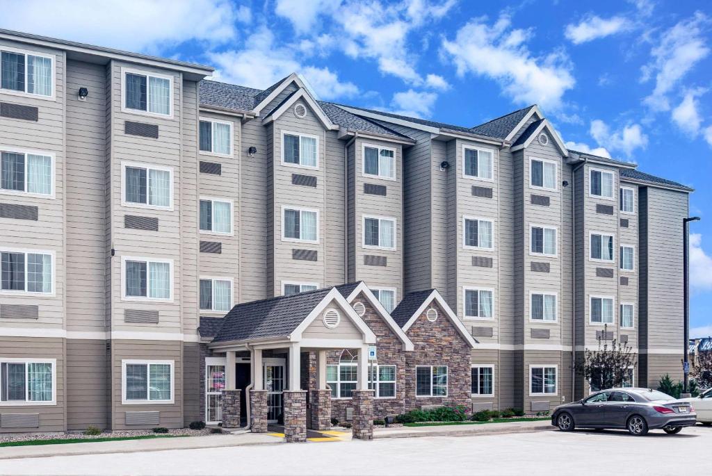 a large apartment building with a car parked in front at Microtel Inn & Suites by Wyndham Williston in Williston