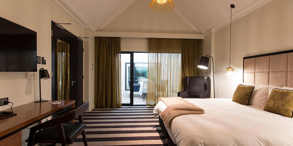 una camera d'albergo con un grande letto e una scrivania di Ellen Hotel a Port Pirie