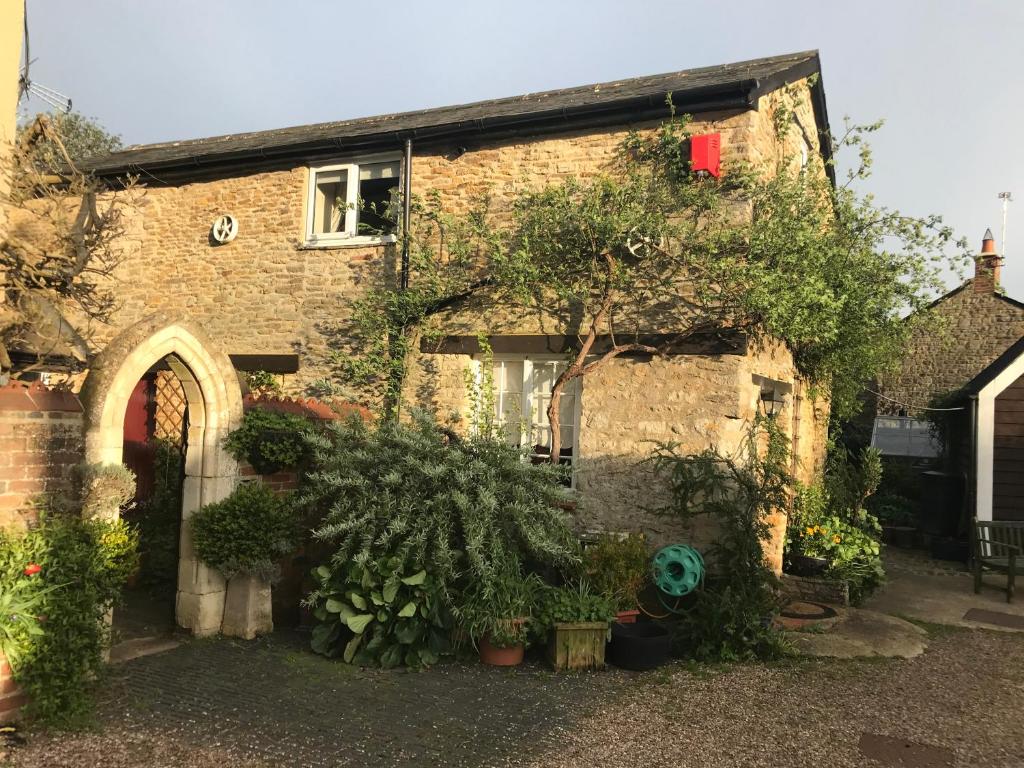 a brick house with plants in front of it at The Annexe Croughton in Banbury