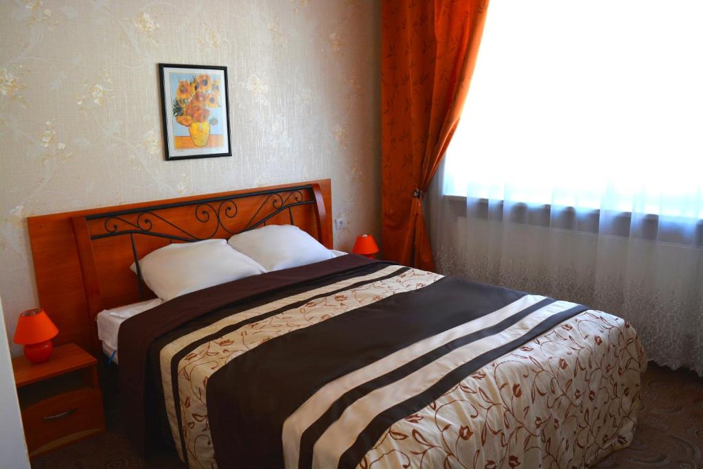 a bedroom with a large bed with a window at Jeruzale Hotel in Vilnius