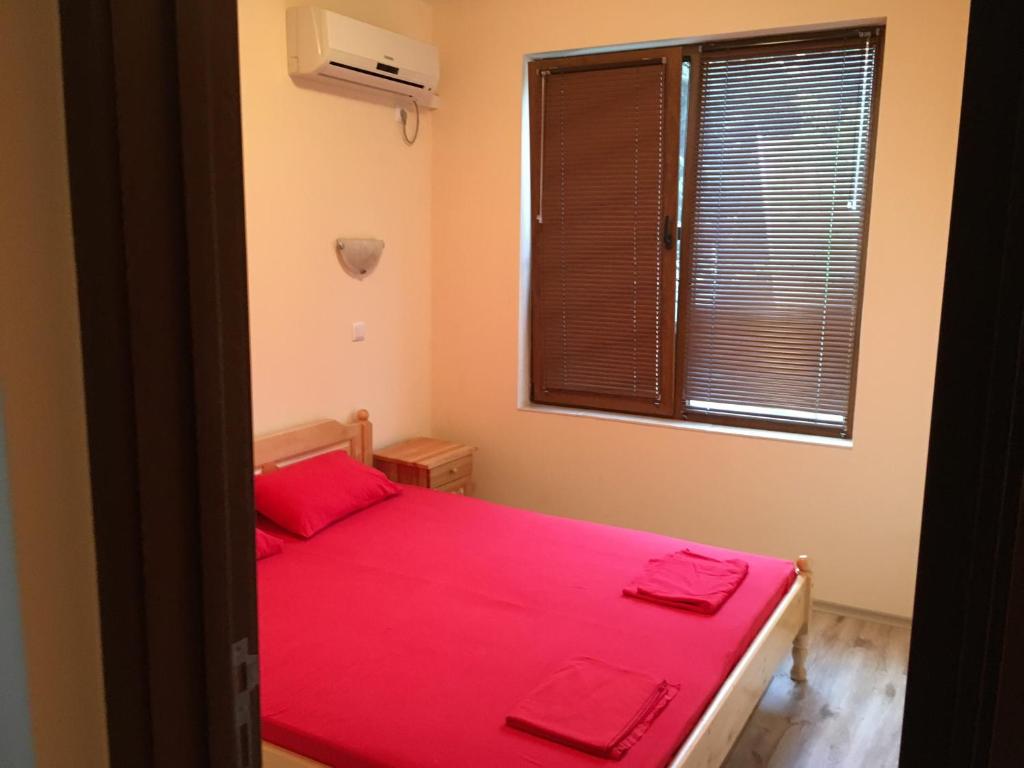 ポモリエにあるApartment Martin Beachのベッドルーム1室(赤いシーツ付きのベッド1台、窓付)