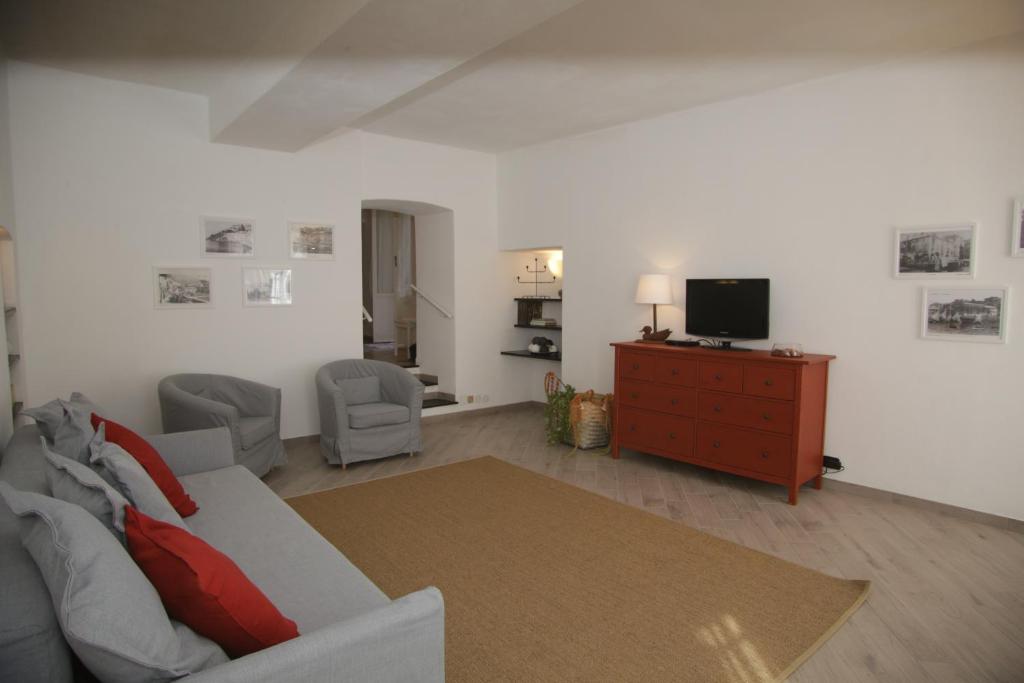 salon z kanapą i telewizorem w obiekcie Posidonia casa al Mare in Città w Genui