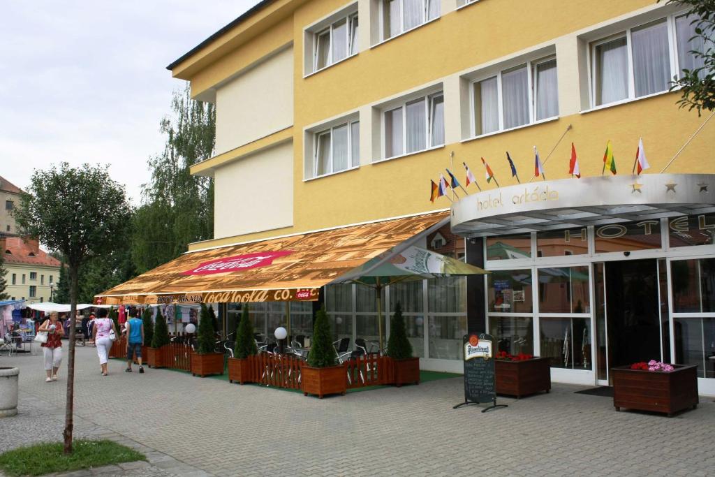 a yellow building with people walking in front of it at Arkada Hotel in Bučovice