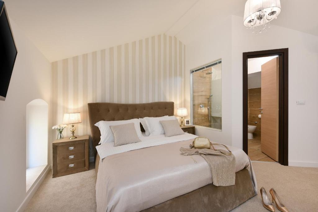 a bedroom with a large white bed and a mirror at Harvey's luxury rooms in Zadar