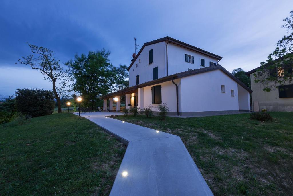 a pathway leading to a white house at night at Room&Breakfast Villa Angela in Sala Baganza