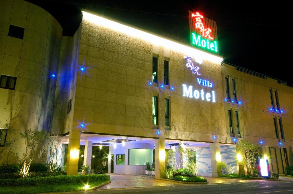 a hotel with neon signs on the side of a building at Fortune Villa Motel in Tamsui