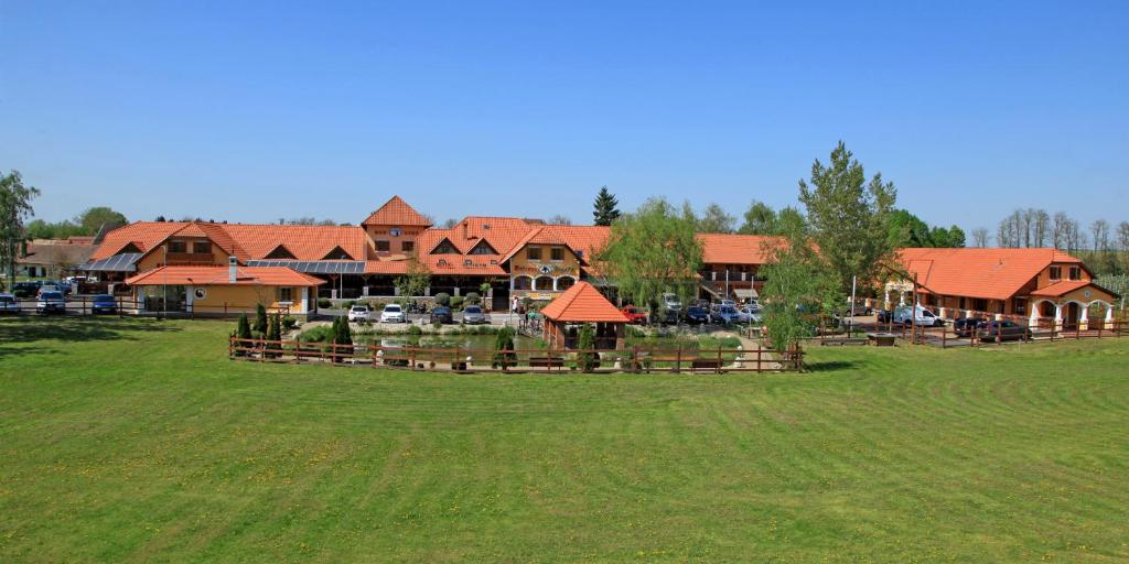 a large house with a grass field in front of it at Berényi Fogadó in Nagykanizsa