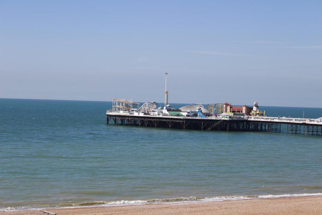 ブライトン＆ホーブにあるThe Brighton Apartment close to beachの浜辺の水辺に座る桟橋