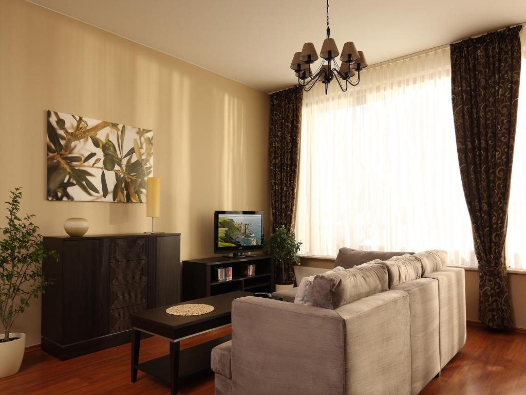 a living room with a couch and a television at Apartamenty Złota Nić in Opole