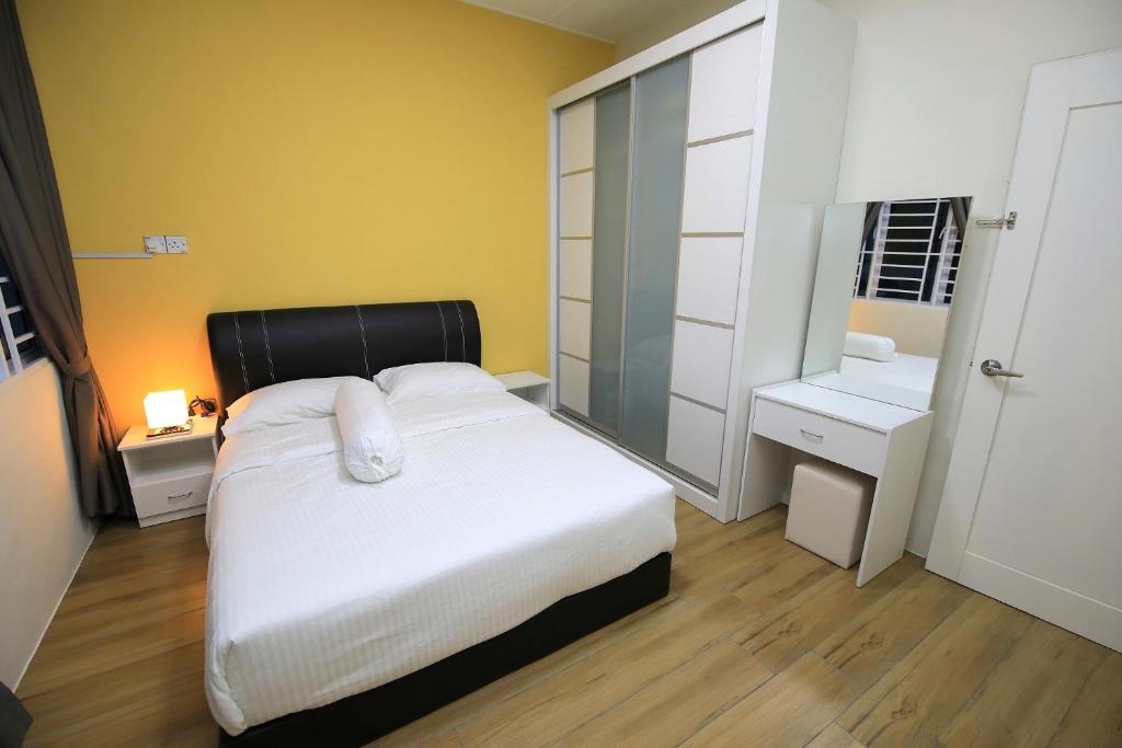 1 dormitorio con cama blanca y espejo en 722 Homestay, en Kuching