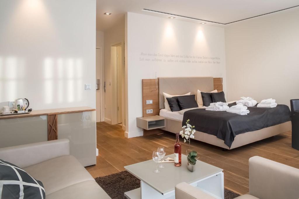 - une chambre avec un lit et un salon dans l'établissement Logierhus Langeoog, à Langeoog