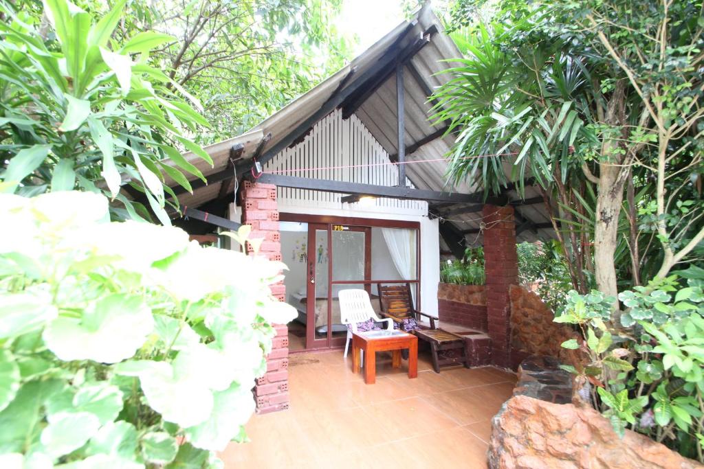 un patio de una casa con mesa y sillas en Pine Bungalow Krabi, en Klong Muang Beach