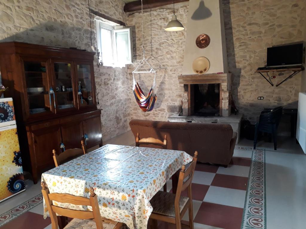 una sala da pranzo con tavolo e camino di Poesia d'Abruzzo CR 06804dueAFFzerozerozerodue a Caramanico Terme