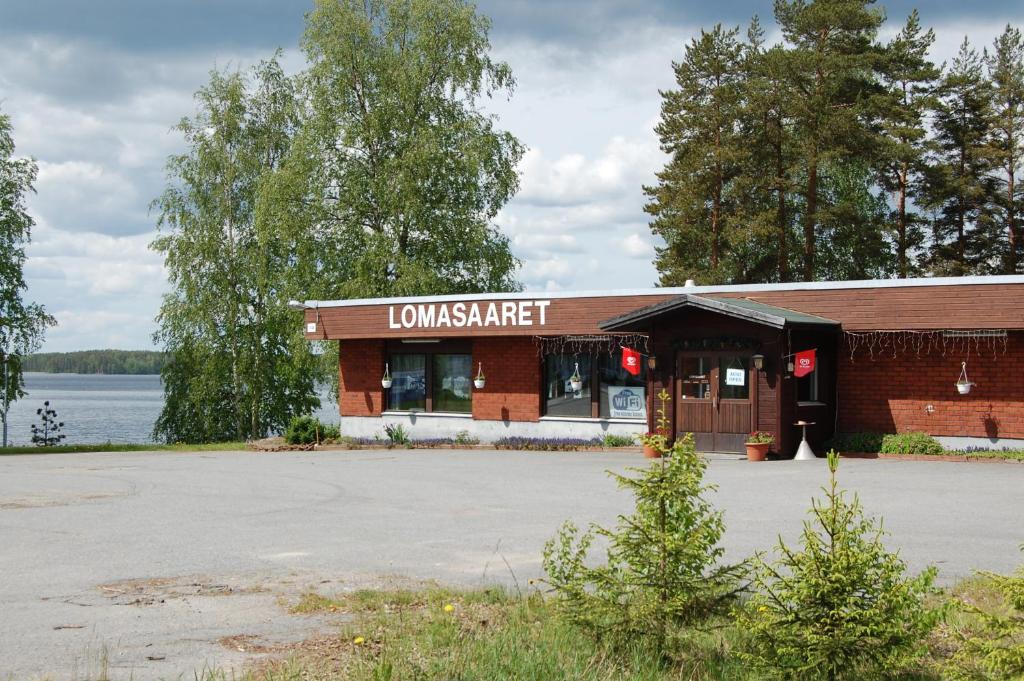 a building with a sign that readsavascriptmastitute next to a lake at Lomasaaret in Villala