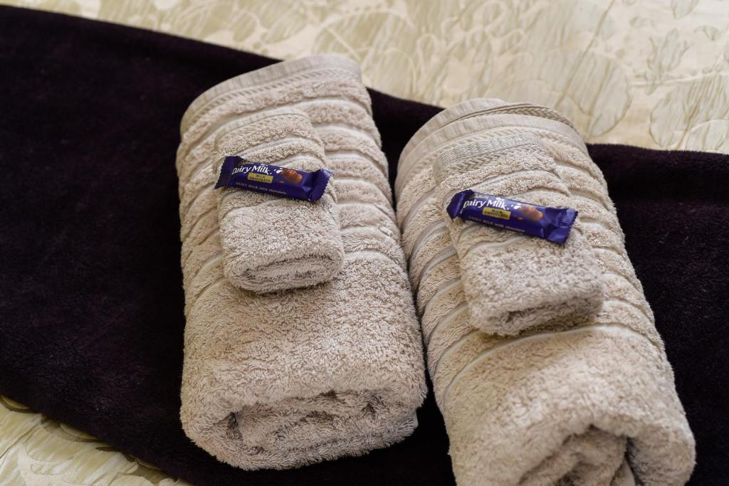 due asciugamani su un letto con sopra degli spazzolini da denti di Sunny Mornington 2 Bedroom Guest Suite a Dunedin