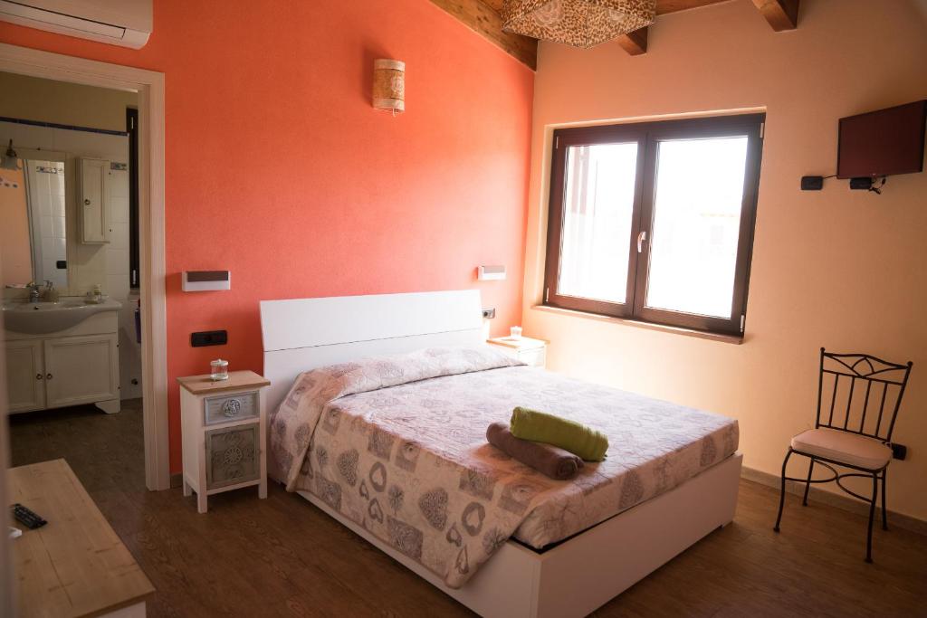 1 dormitorio con cama, ventana y silla en Room & Breakfast Le Magie, en Sindia