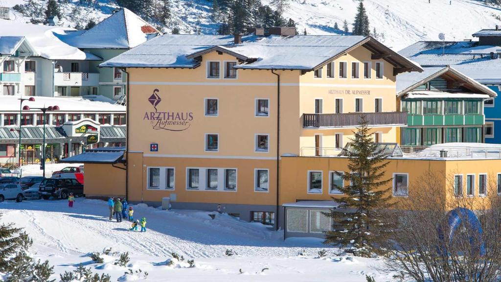 a large building in the snow in front of a mountain at Dr. Aufmesser Appartements in Obertauern