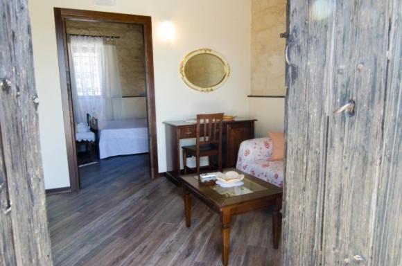 sala de estar con mesa y sofá en Agriturismo Margione, en Módica