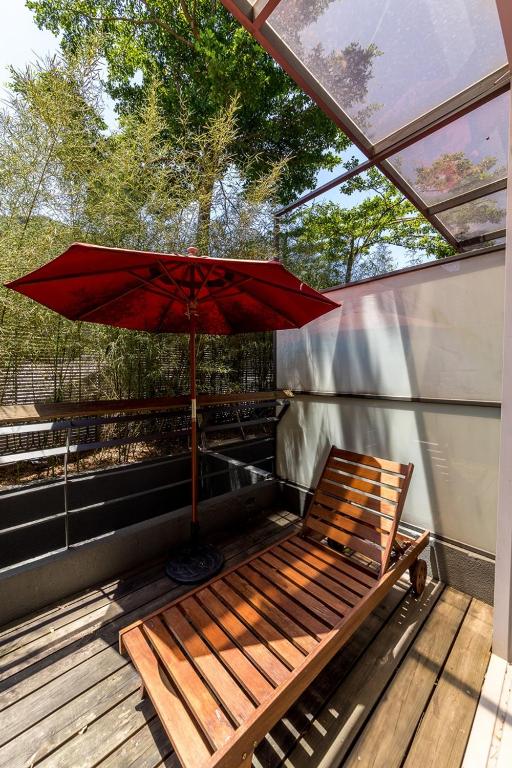 a wooden bench with an umbrella on a deck at Hotel Double One in Taipei