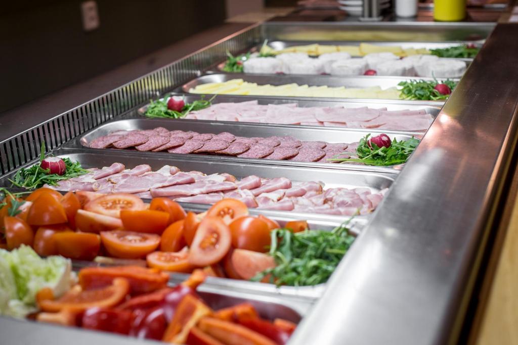 a buffet filled with different types of meats and vegetables at Hotel Páv in Prague