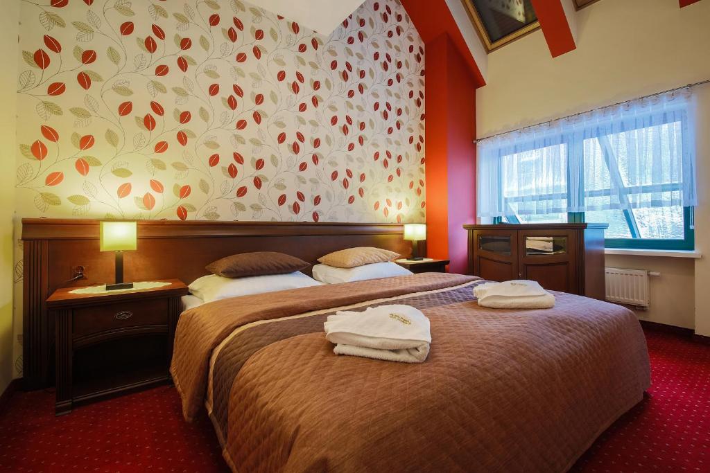 - une chambre d'hôtel avec 2 lits et des serviettes dans l'établissement Apartamenty przy Głównym Deptaku, à Wisła
