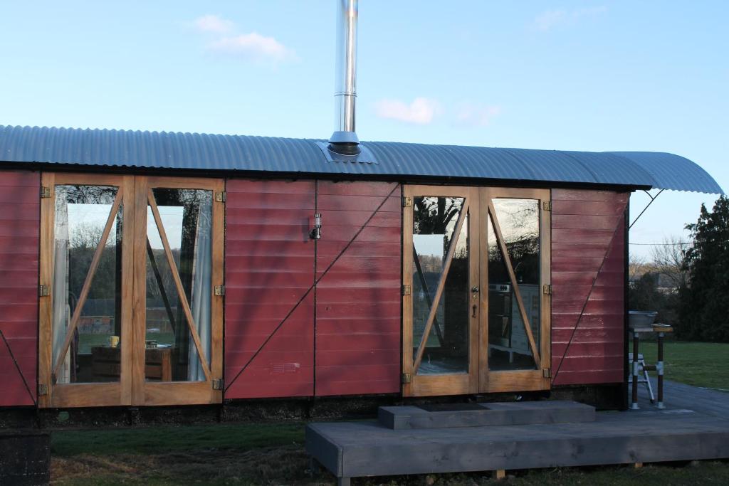 オスウェストリーにあるOff the Railsの金属屋根と窓のある赤い家