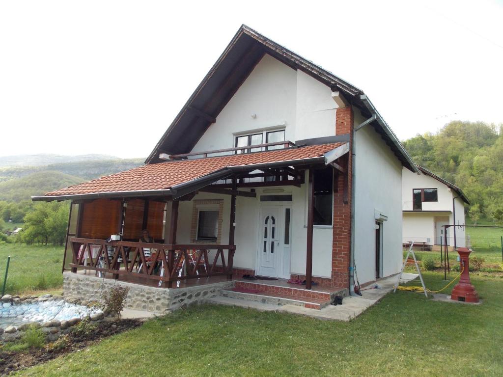 uma pequena casa branca com um alpendre em Villa MIR em Mokra Gora