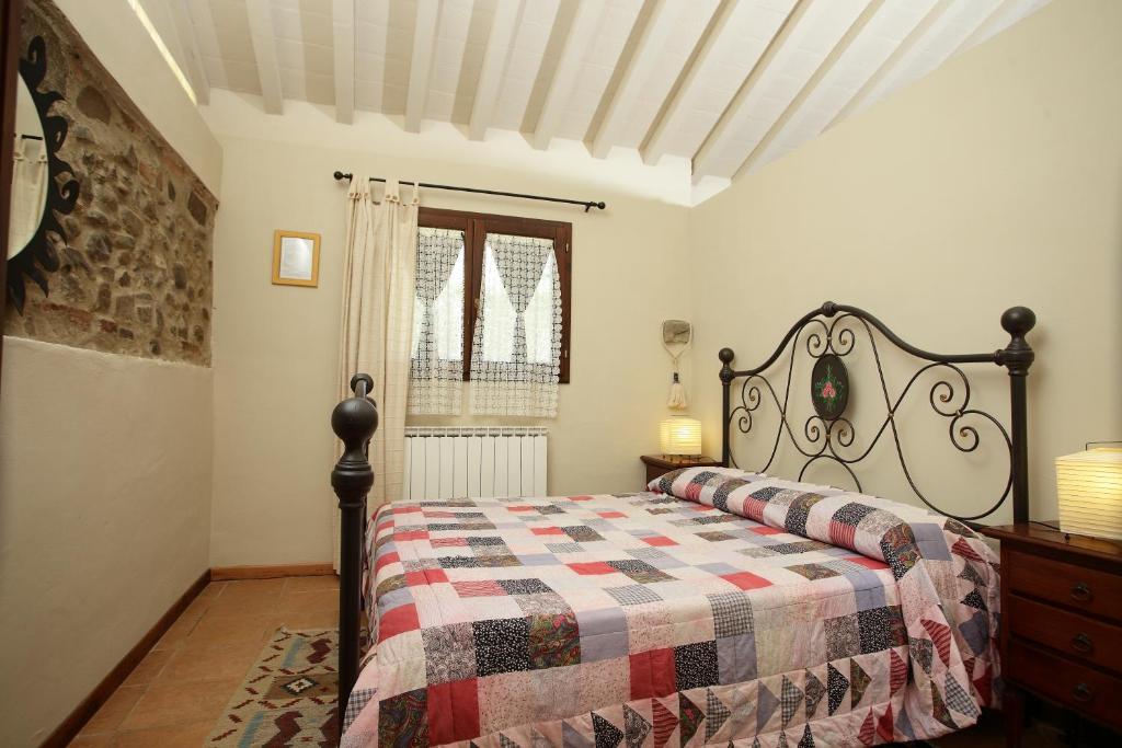 a bedroom with a bed with a quilt on it at Osteria I'Casolare in San Giovanni Valdarno